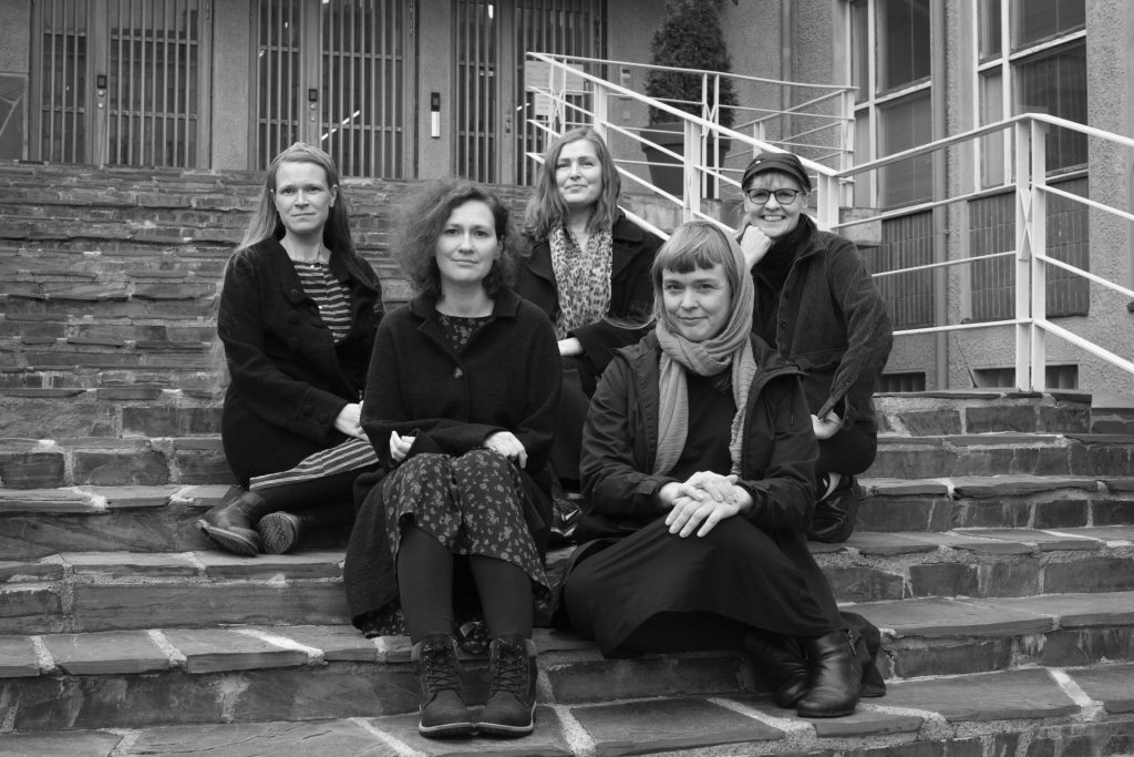 A group of five women sitting on stairs